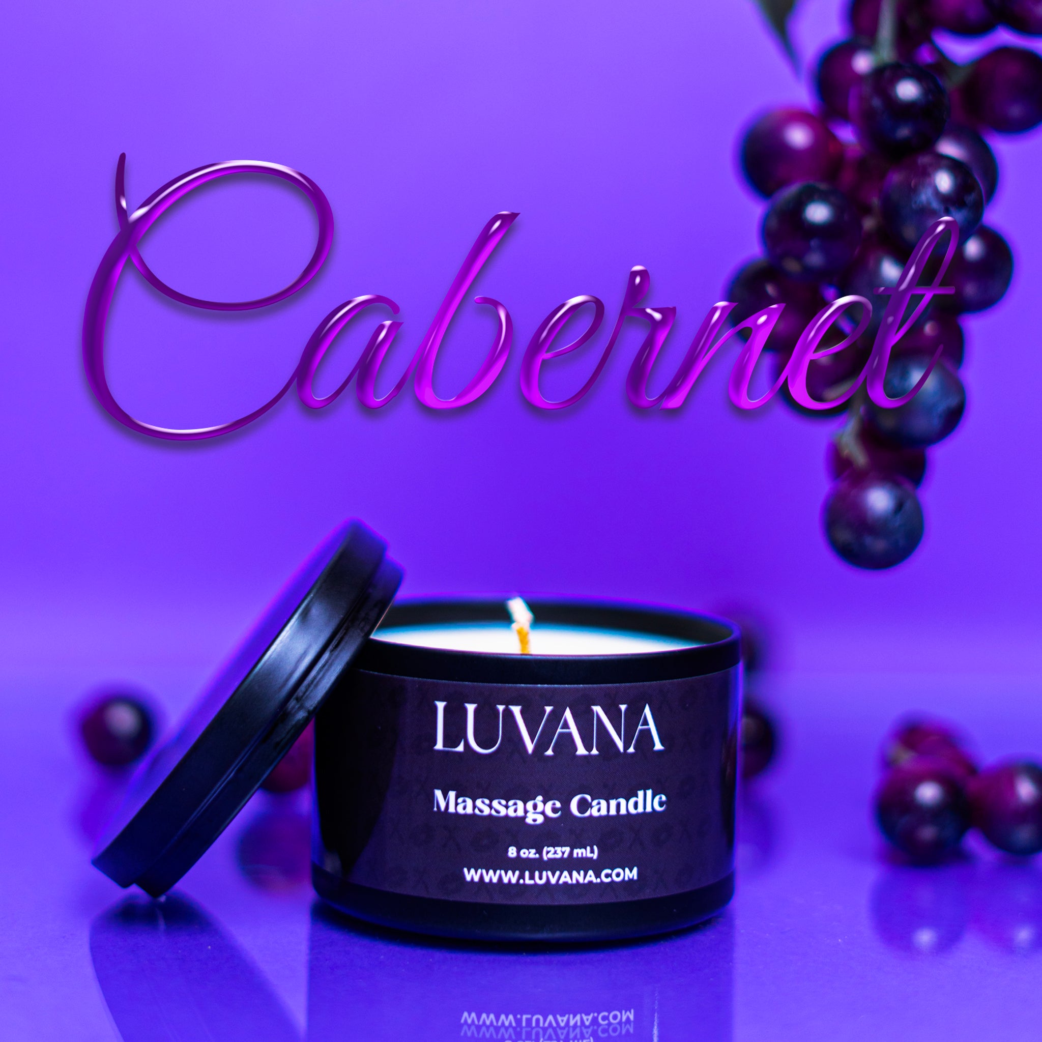 Luvana Massage Candle in Cabernet scent on purple background with grapes, soy wax massage oil candle made in Puerto Rico.