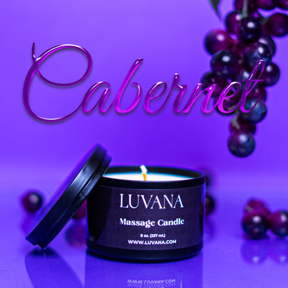 Luvana Massage Candle in Cabernet scent on purple background with grapes, soy wax massage oil candle made in Puerto Rico.