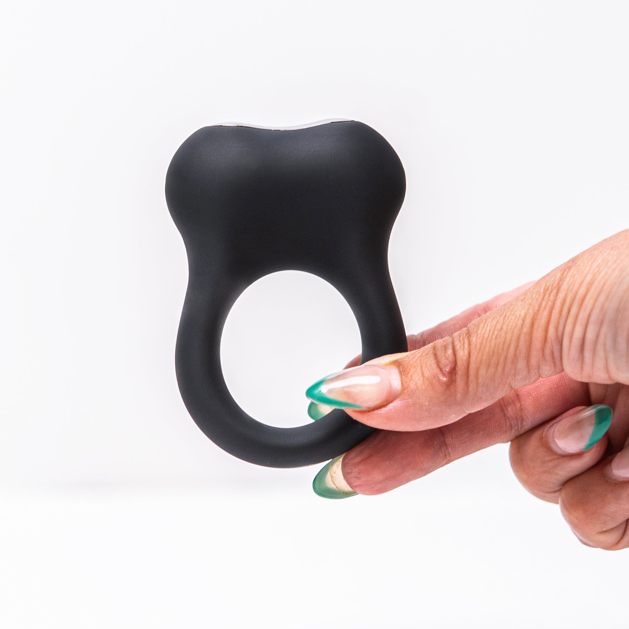 Hand holding the Halo X vibrating cock ring, showing its compact shape and soft silicone design.