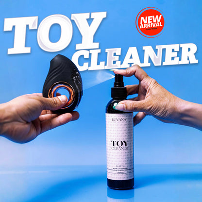 Hands spraying Luvana Toy Cleaner onto a black silicone toy on a blue background with “Toy Cleaner” text and a New Arrival badge.