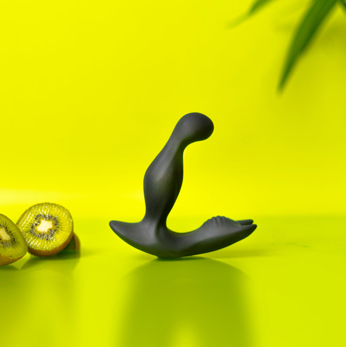 Luvana Knight Ryder silicone prostate massager on lime green set with whole kiwis and fruit slices.