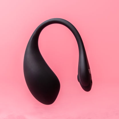 Luvana Duo Bliss black wearable couples vibrator floating product photo on pink background, sleek body-safe silicone design