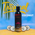 Luvana Edible Massage Oil in Tropical Coconut flavor standing on sand with coconut halves and a palm leaf, with “Tropical Coconut” text on a blue background.