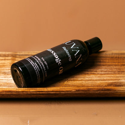 Luvana Lavender Massage Oil bottle on wooden tray with warm background, relaxing massage and body oil made in Puerto Rico.