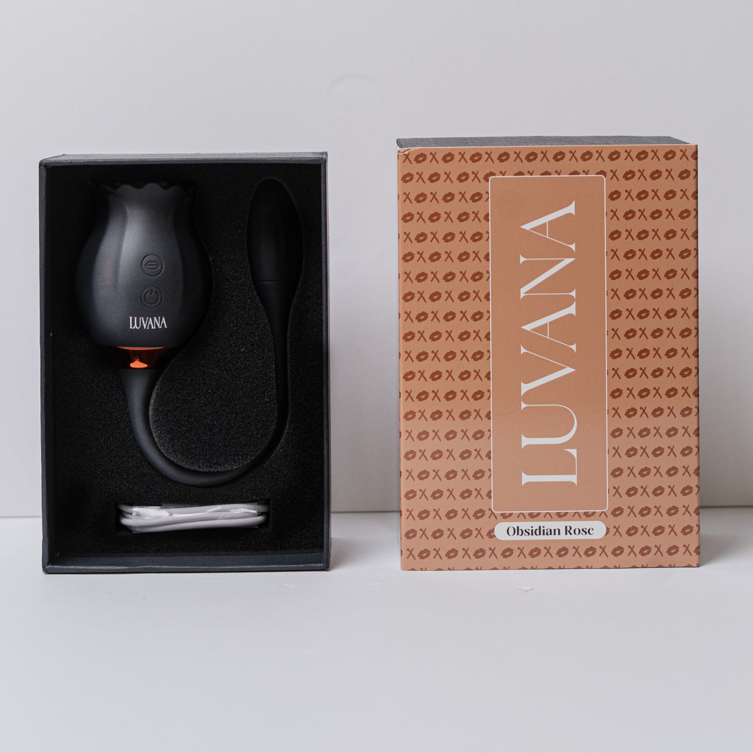 Black Luvana Obsidian Rose vibrator with rose design and control buttons, surrounded by red rose petals