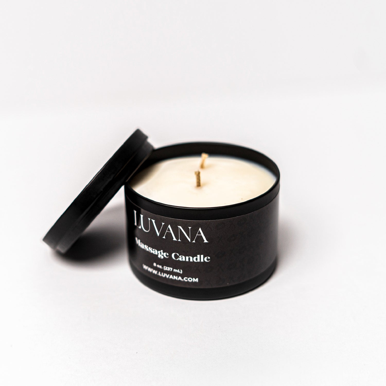 Open Luvana Massage Candle jar with lid beside it on white background, soy wax massage oil candle made in Puerto Rico.