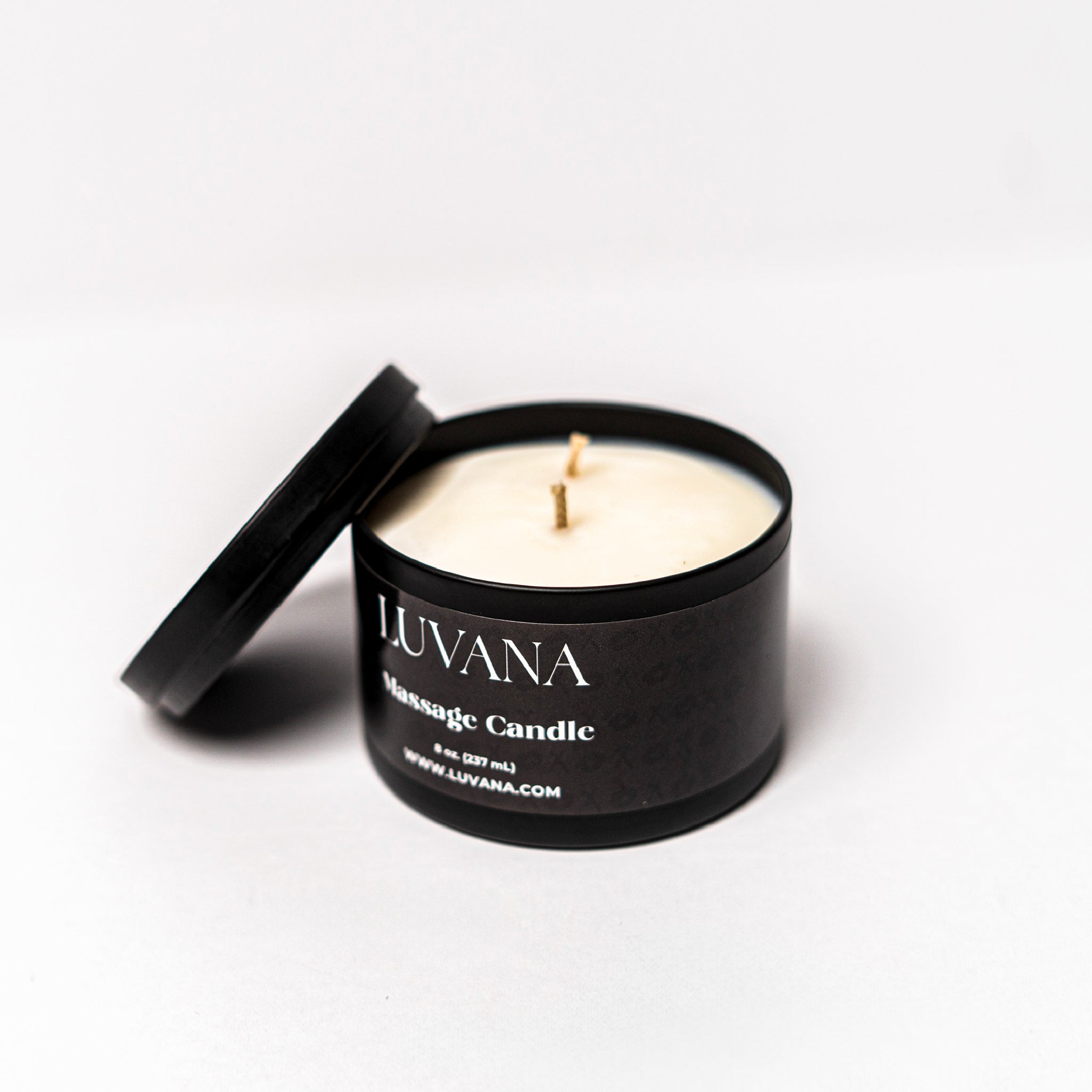 Open Luvana Massage Candle jar with lid beside it on white background, soy wax massage oil candle made in Puerto Rico.