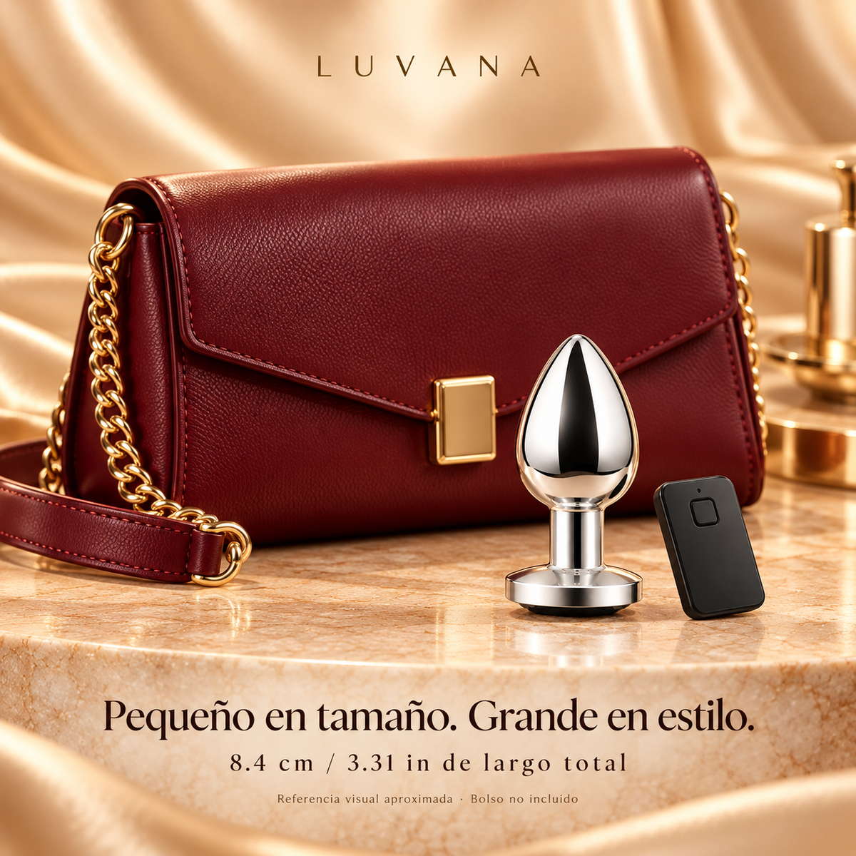 Chrome X silver vibrating anal plug and remote next to a burgundy evening purse for approximate size reference. Overall product length 8.4 cm / 3.31 in; purse not included.